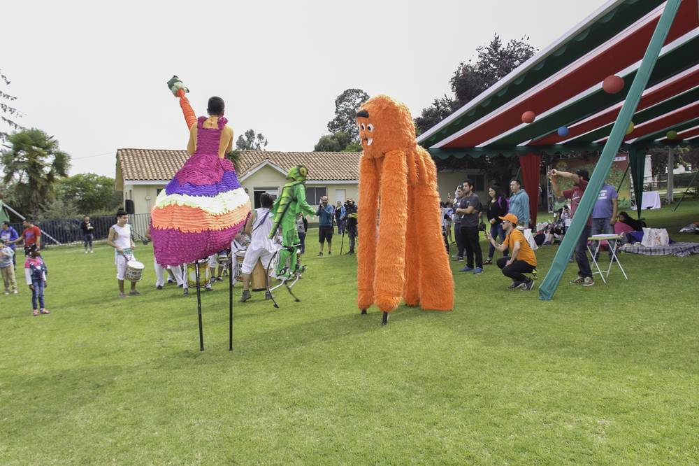 Personajes en zancos y comparsa de tambores en evento familiar